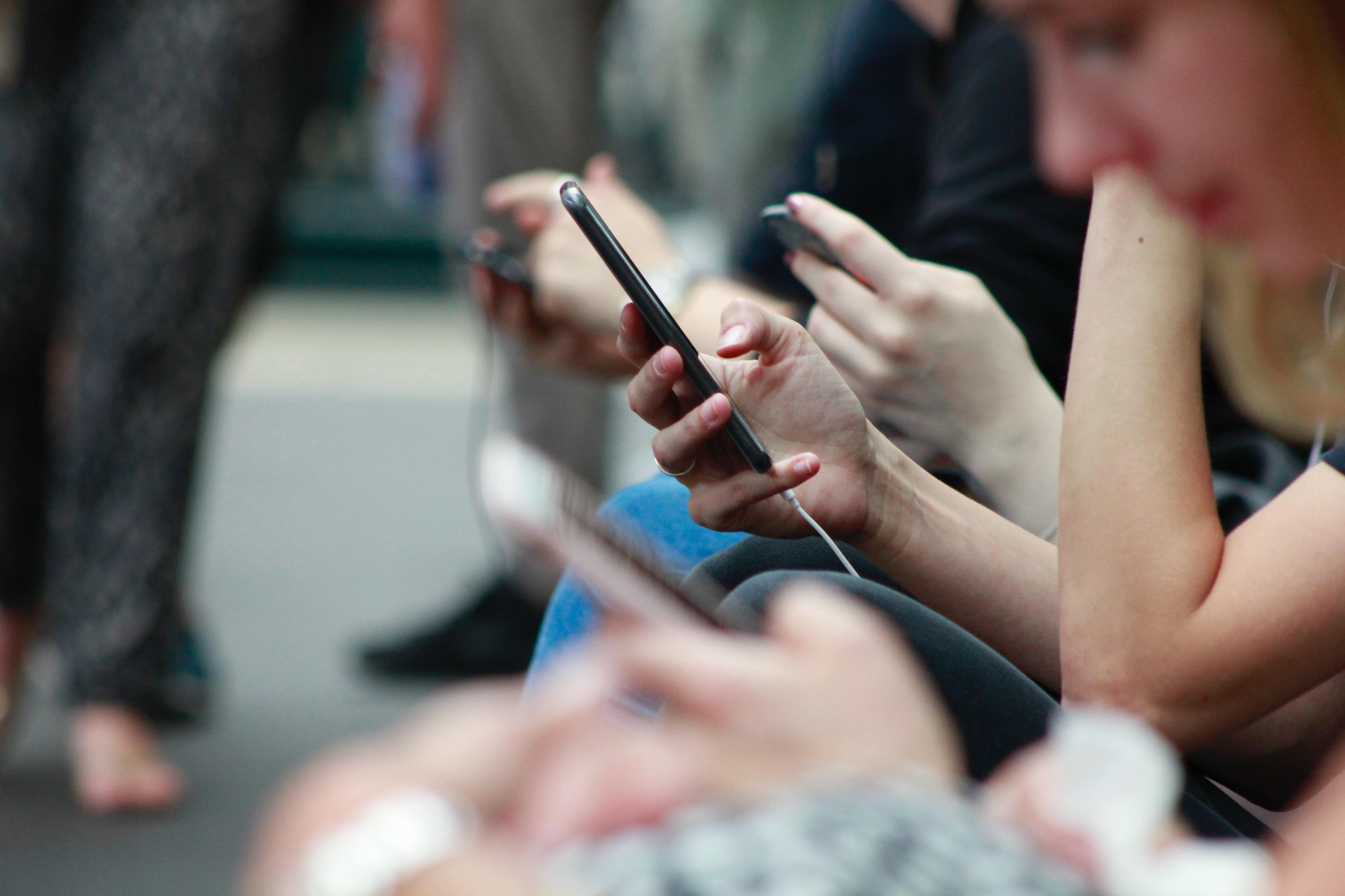 Customers sitting on their mobile phones looking at their screens